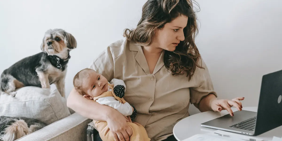 The Struggles of Balancing Work and Home The Struggles of Balancing Work and Home | A mom working while holding a baby